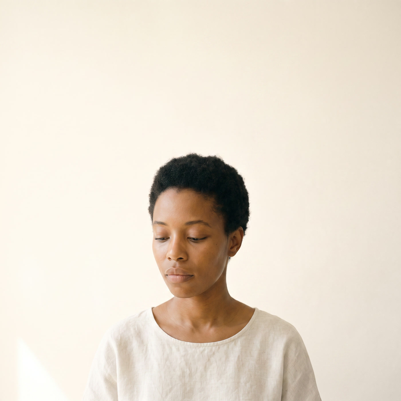 A woman in profile, thinking, in soft light.